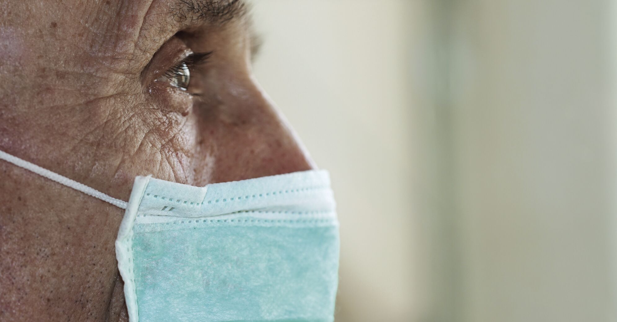 face of elderly man wearing medical facemask